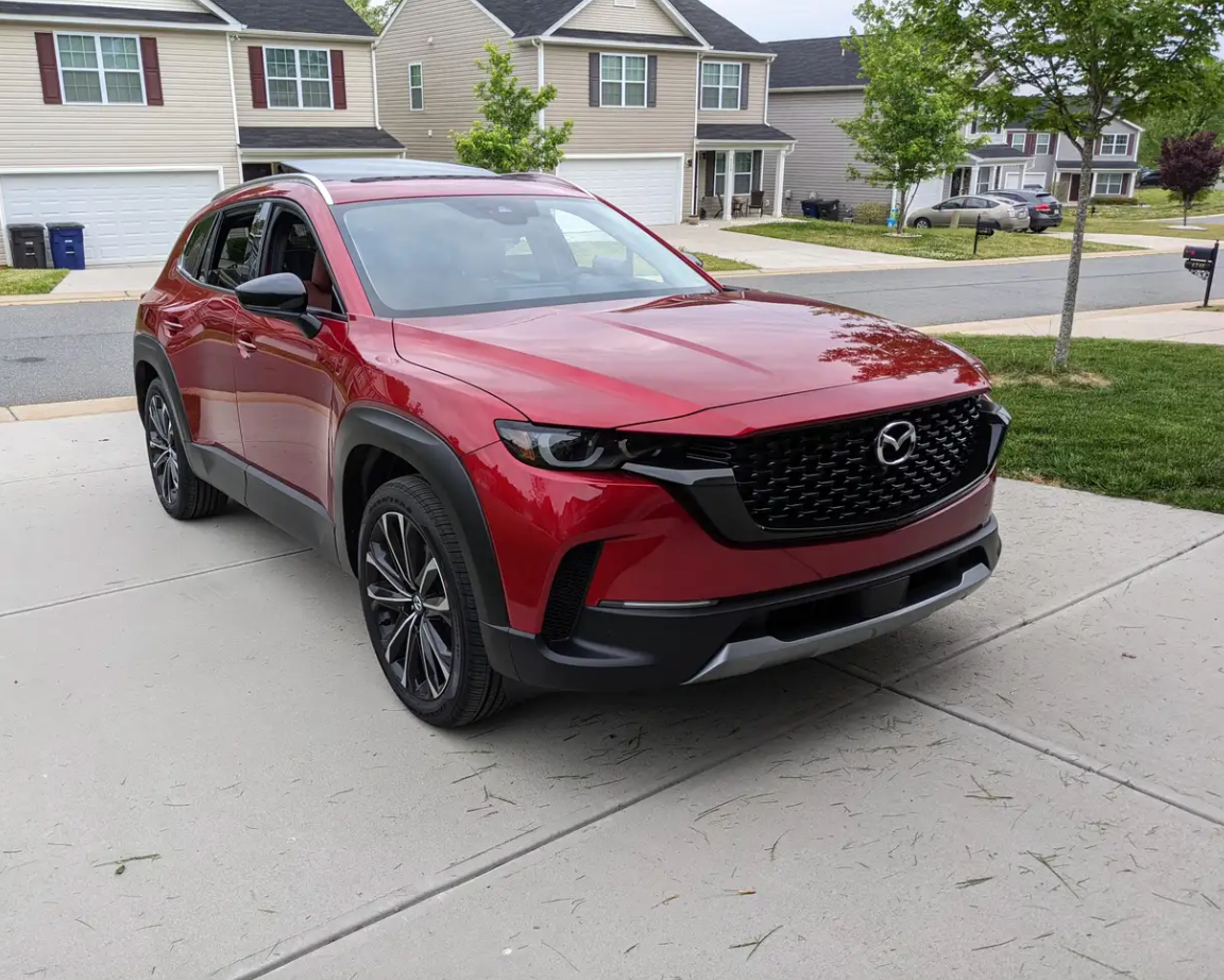 A red Mazda CX-50 parked on a driveway