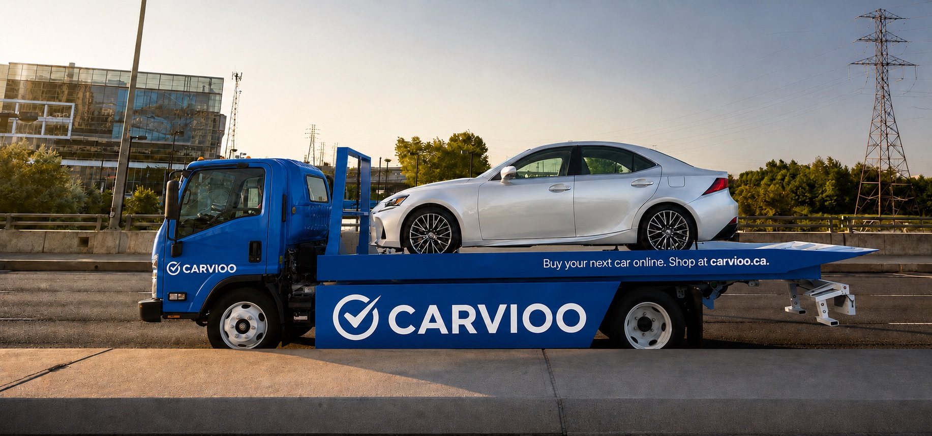 A Carvioo flatbed carrying a silver sedan